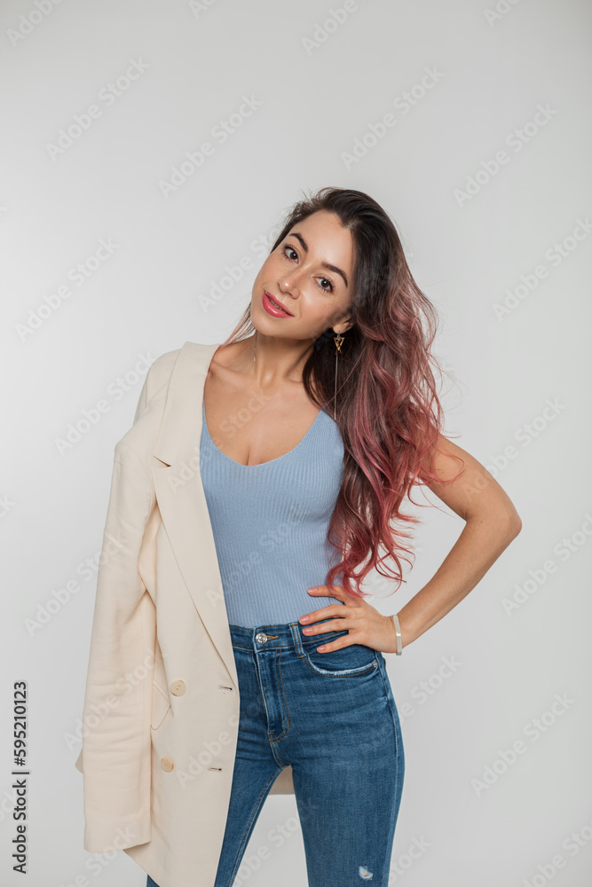 Fashionable beautiful young woman model with pink hair in stylish casual outfit with a blazer on her shoulder posing in the studio on a white background Fashionable beautiful young woman model with pink hair in stylish casual outfit with a blazer on her shoulder posing in the studio on a white background