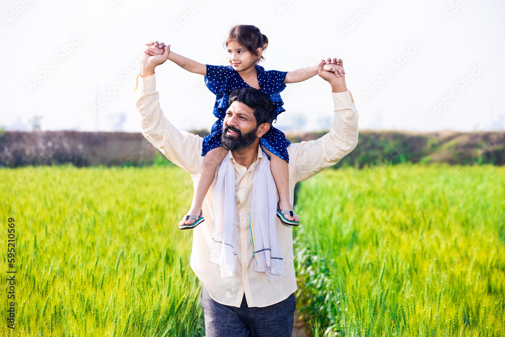 Happy Indian little daughter sitting on father shoulder having fun walking in wheat agriculture field, spend leisure time together in farm, girl child enjoy outdoor, relationship bonding. Happy Indian little daughter sitting on father shoulder having fun walking in wheat agriculture field, spend leisure time together in farm, girl child enjoy outdoor, relationship bonding.