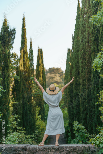 happy woman wearing a fedora hat while standing in the woods