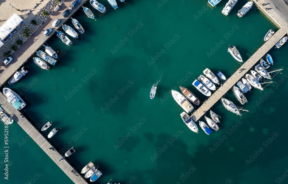 Drone aerial scenery of a fishing port. Fishing boats and yachts  moored in the harbour