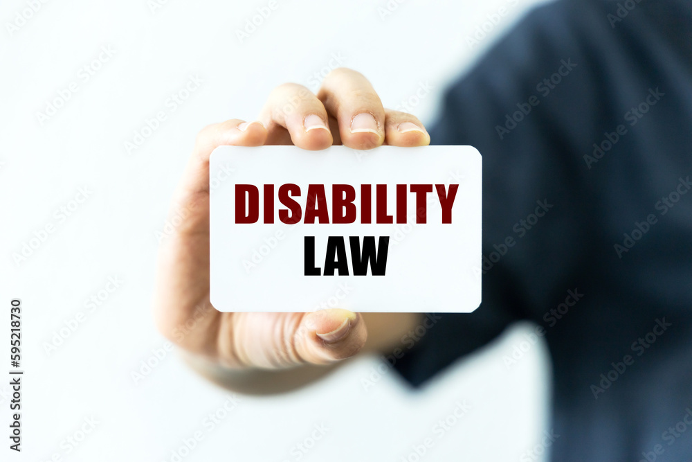 Disability law text on blank business card being held by a woman's hand with blurred background. Business concept about disability law. Disability law text on blank business card being held by a woman's hand with blurred background. Business concept about disability law.