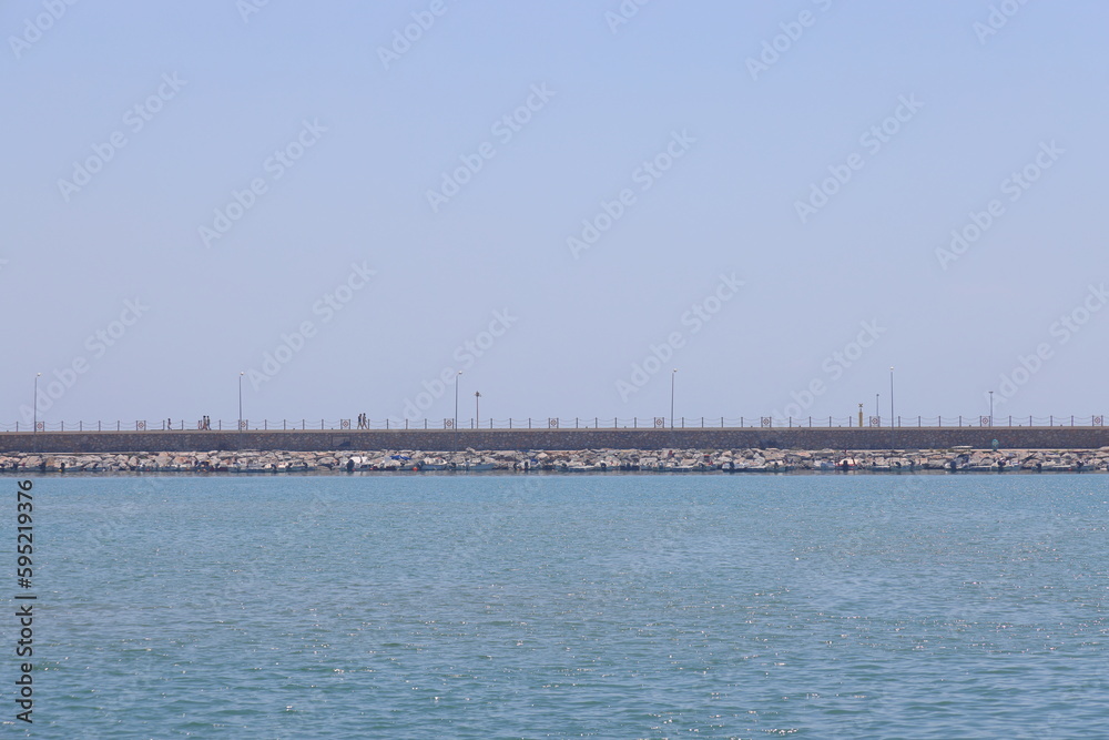 View of the pier in the port of Alanya, minimalism, the Mediterranean Sea. Sunny day. Türkiye, April 2023.