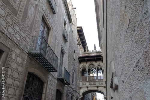 View of the Pont del Bisbe, a striking Gothic-style bridge built in 1928, located at Carrer del Bisbe in the Gothic Quarter, the historic heart of Barcelona, Spain. 