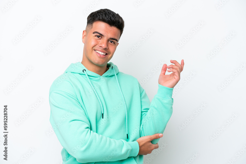 Young caucasian handsome man isolated on white background extending hands to the side for inviting to come Young caucasian handsome man isolated on white background extending hands to the side for inviting to come
