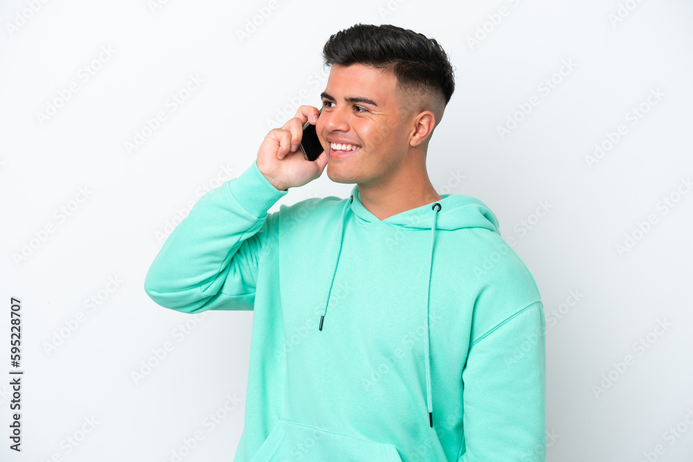 Young caucasian handsome man isolated on white background keeping a conversation with the mobile phone Young caucasian handsome man isolated on white background keeping a conversation with the mobile phone