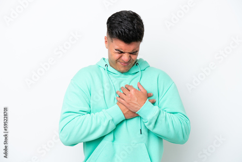 Young caucasian handsome man isolated on white background having a pain in the heart