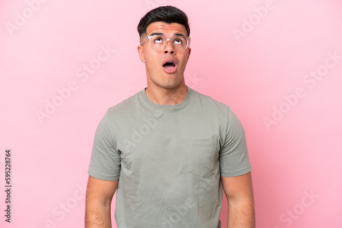 Wallpaper Mural Young caucasian handsome man isolated on pink background looking up and with surprised expression Torontodigital.ca