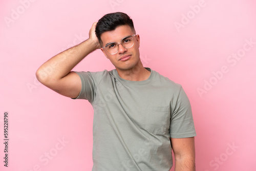 Young caucasian handsome man isolated on pink background with an expression of frustration and not understanding