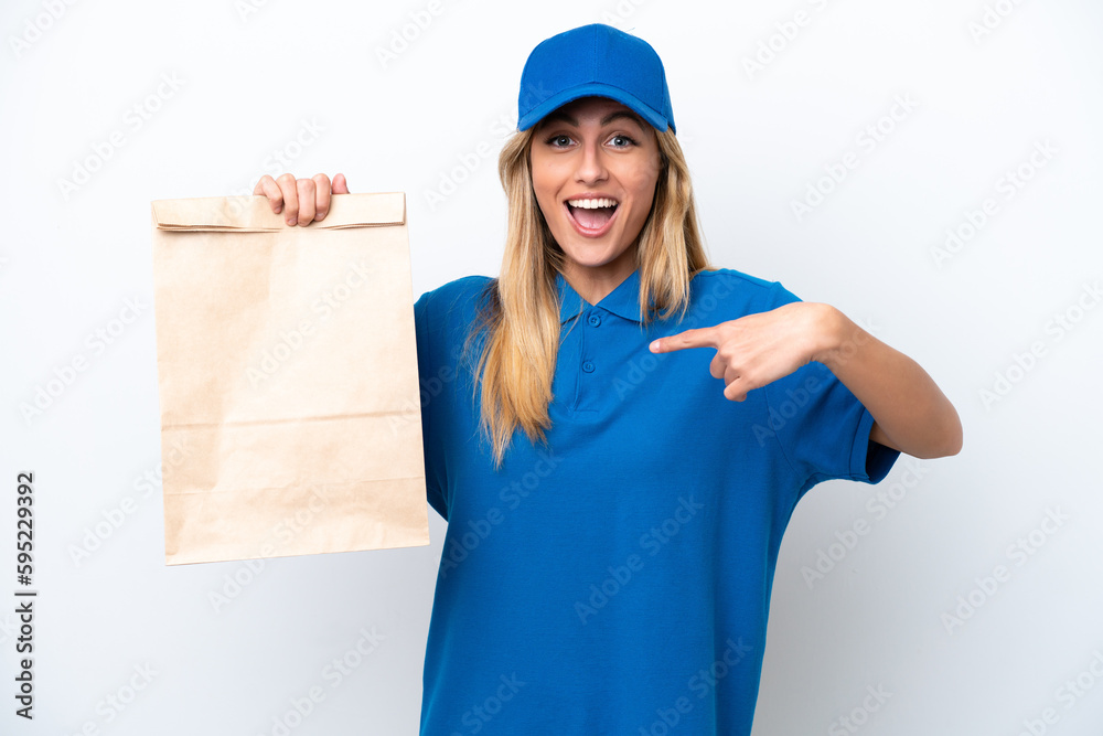 Young Uruguayan woman taking a bag of takeaway food isolated on white background with surprise facial expression Young Uruguayan woman taking a bag of takeaway food isolated on white background with surprise facial expression
