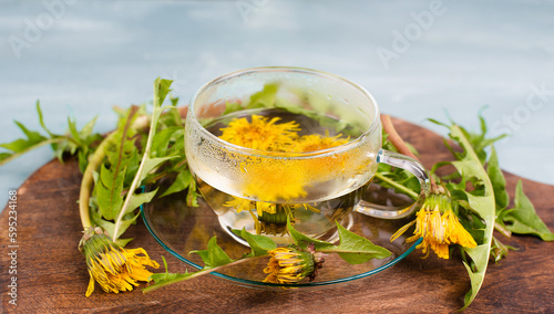 Dandelion wildflower tea, glass with herbal hot drink, alternative medicine for detox, leaves and flowers
