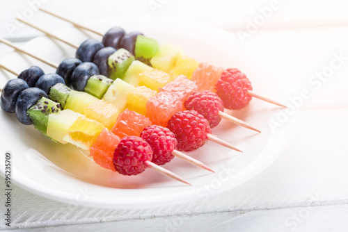 Kebab with raspberries, kiwi, orange and other fruits on the plate