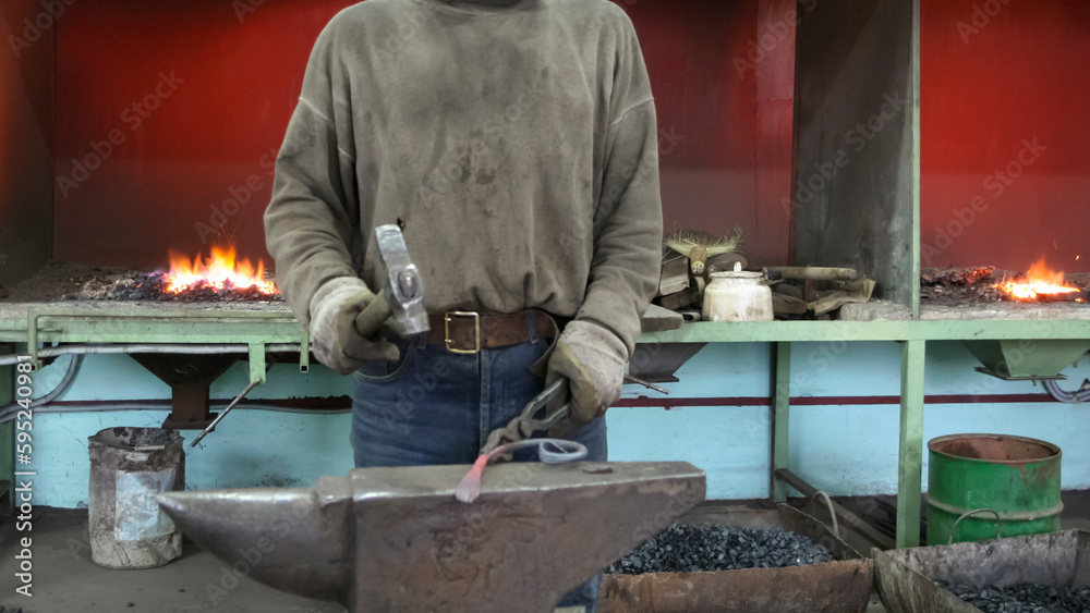 Blacksmith at work in the smithy Blacksmith at work in the smithy