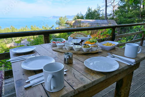 A delicious Mediterranean breakfast of fresh fruit and other nourishing foods served on a table overlooking the sea, creating an atmosphere of wellbeing.