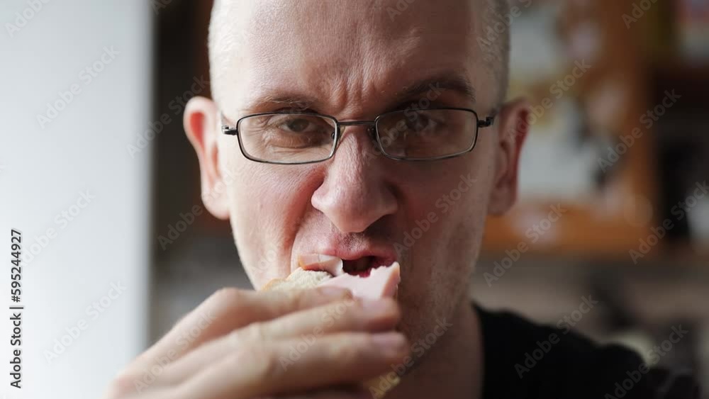 man with glasses eating a sandwich man with glasses eating a sandwich