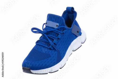 Blue sneaker made of fabric with a white sole on a white shoe.