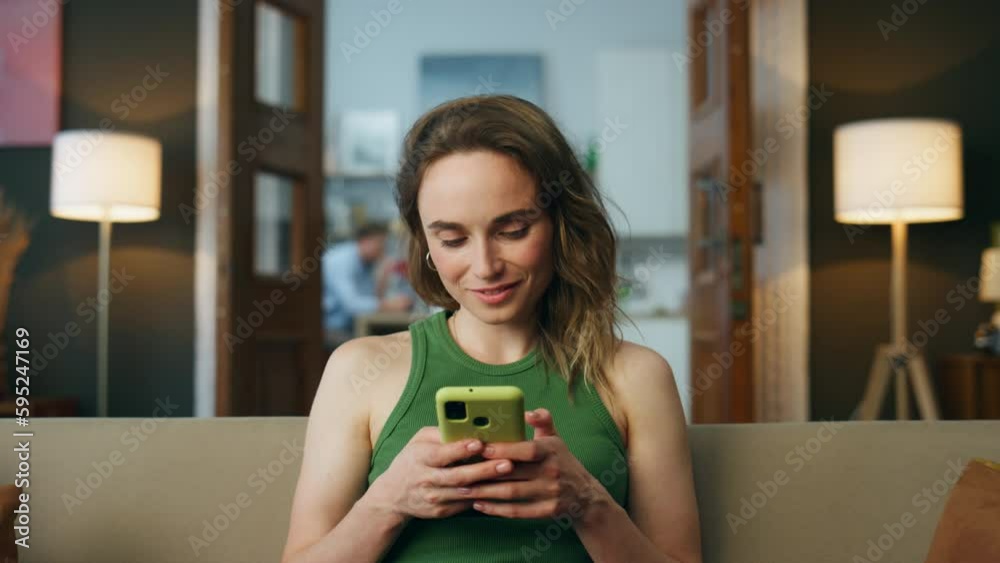 Smiling woman texting telephone living room zoom on. Woman chatting mobile phone