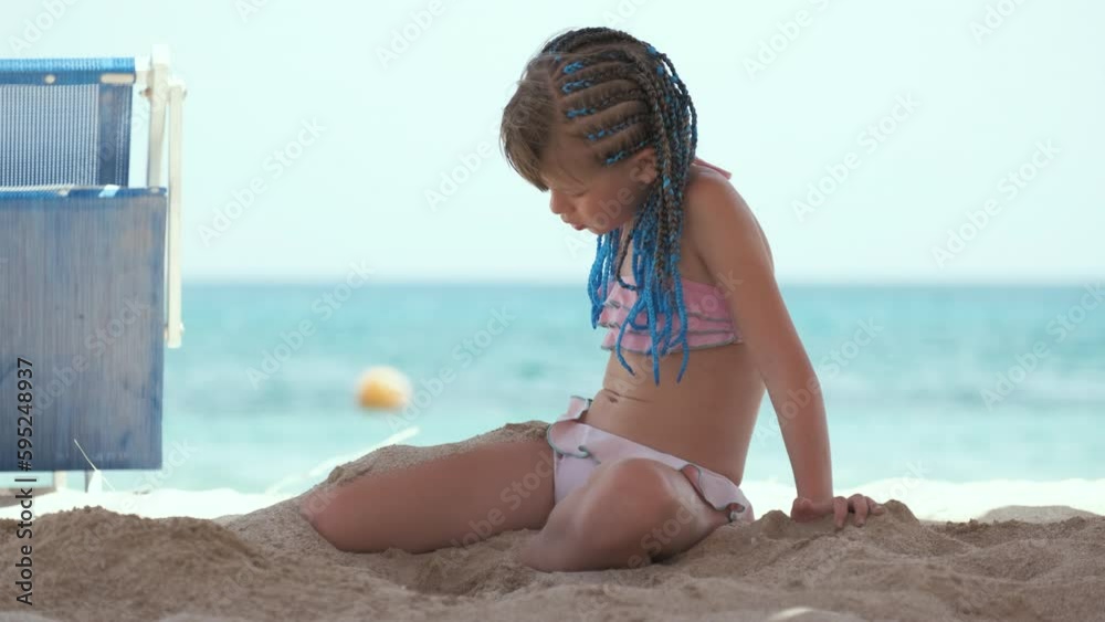 Happy child girl in bikini swimsuit playing with sand on seaside beach during summer tropical vacation Stock Video | Adobe Stock      