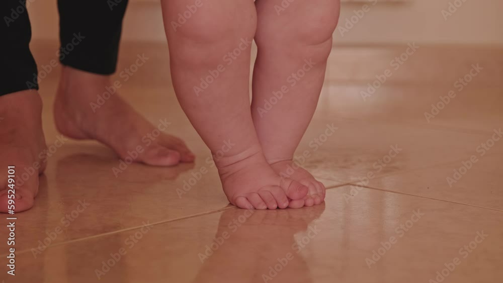 Sall baby feet, trying to walk for the first time. Adorable infant with his smother making his first steps. Close-up slow-motion video of a Caucasian one-year-old boy walking for the first time. . Sall baby feet, trying to walk for the first time. Adorable infant with his smother making his first steps. Close-up slow-motion video of a Caucasian one-year-old boy walking for the first time. .
