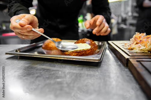 chef hand cooking cheeseburger on restaurant kitchen