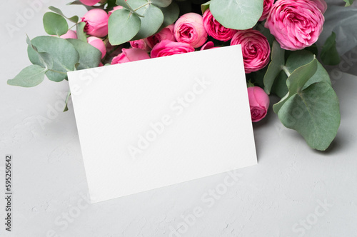 Invitation or greeting card mockup with fresh roses flowers and eucalyptus