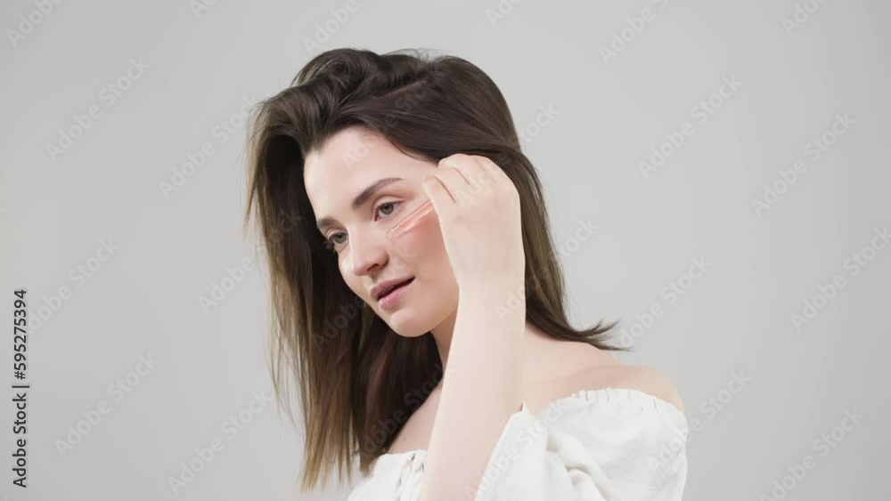 Woman applying face serum with moisturizing dropper, morning skin care. Beautiful woman uses face oil with dropper and moisturizes her cheeks, health and face care concept Woman applying face serum with moisturizing dropper, morning skin care. Beautiful woman uses face oil with dropper and moisturizes her cheeks, health and face care concept