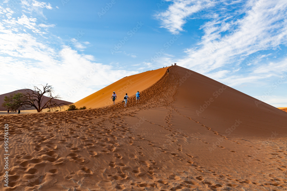 Tourists climbing up the famous Sossusvlei Dune 45 in the Namib Desert ...