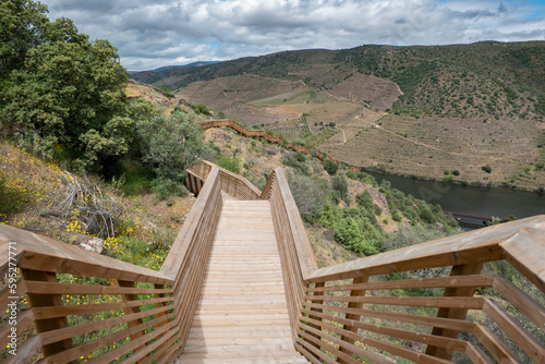 Entre montanhas os Passadiços do Côa, estrutura em madeira com o cumprimento de 930 de extensão e 890 degraus, com o rio Douro ao fundo em Foz Côa, Portugal num dia nublado