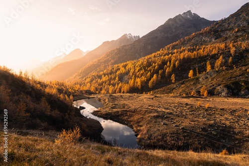 Landscape view of an autumn sunset over the Grundsee mountain lake surrounded by golden larches