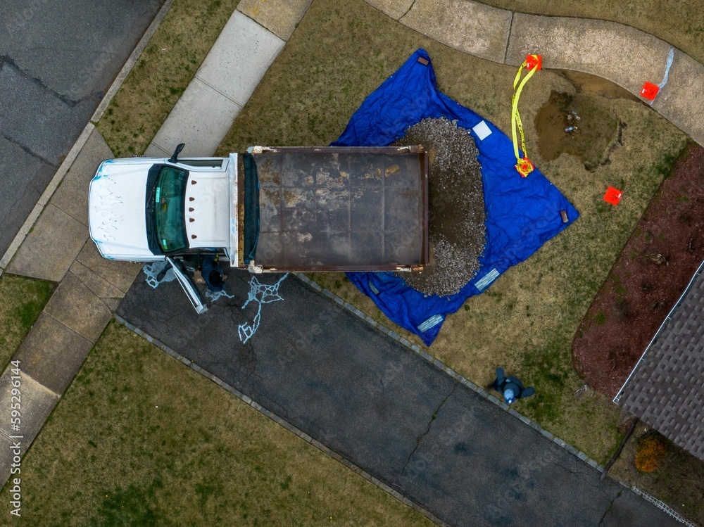 Aerial view of a construction site with soil being loaded into a yard by a truck