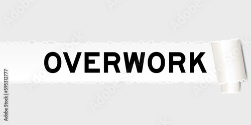 Ripped gray paper background that have word overwork under torn part