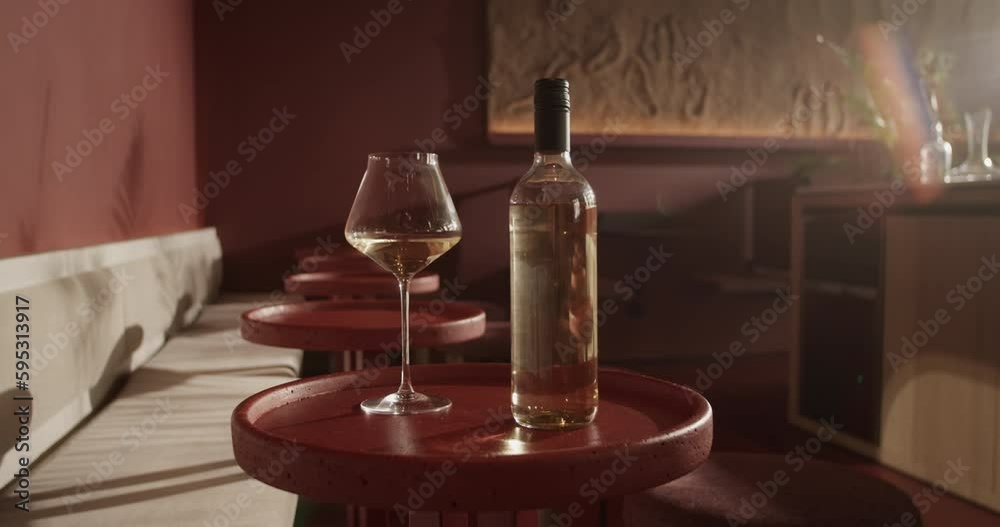 Bottle of wine placed on round table with wineglass Bottle of wine placed on round table with wineglass