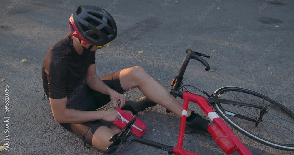 fit man fell off bicycle on the ground and injured his knee. bike accident Biker crash crashes, injuring knee and leg, First aid to help biker in accident. road accident.