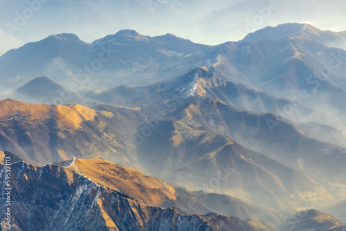 Aerial view of morning sunlight on Summer Alps, hazy valleys