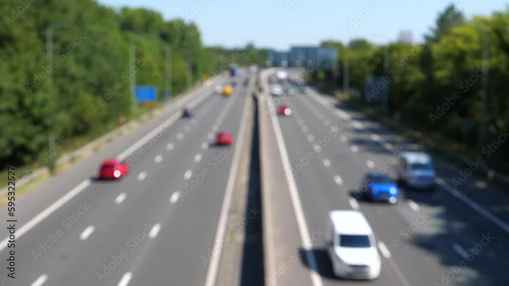 Blurred high angle view of cars and trucks moving smoothly on a highway in England on a nice sunny summer day.