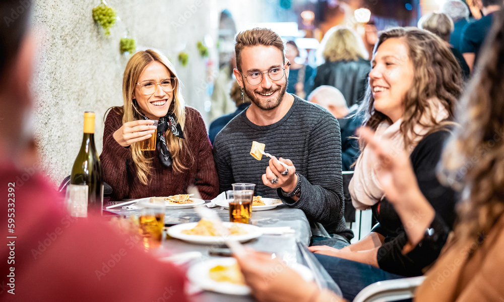 Trendy people having fun drinking white wine at street food event - Happy friends eating local meal plates at open air restaurant together - Food and beverage life style concept on bulb light filter