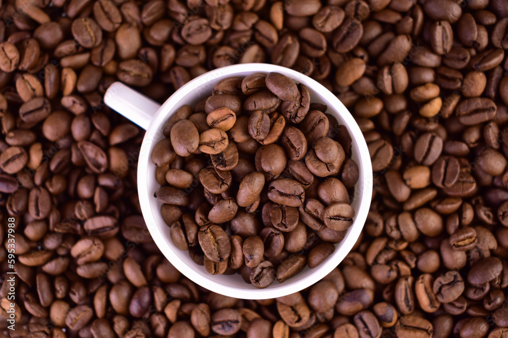 Cup with coffee beans on the background of coffee beans.
