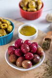 Red kalamata olives on wooden background. Red and green kalamata olives.