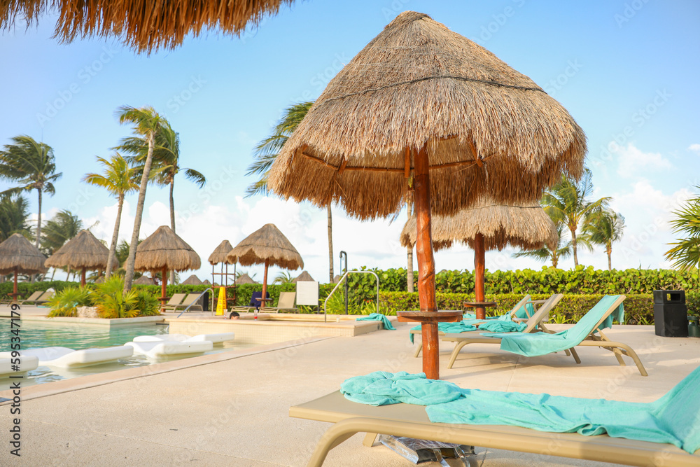 palapa sun roof beach umbrella by the beach symbolizes relaxation, shade, and protection. It represents a tropical, beachy atmosphere and the desire to escape from the sun's harsh rays