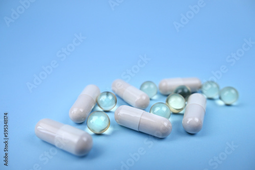 Assorted pharmaceutical medicine pills, tablets and capsules on wooden spoon