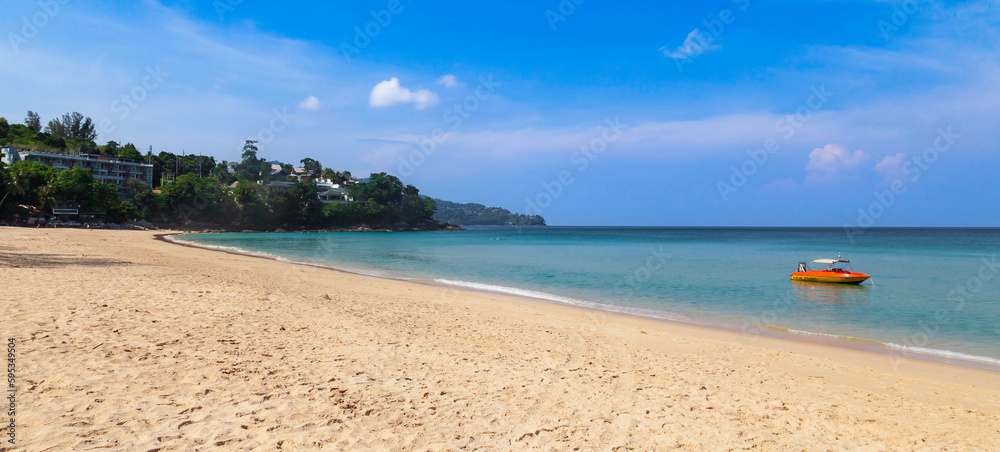 Beautiful Surin beach in Choeng Thale city, Phuket, Thailand with white sand, turquoise water, boat and palm trees