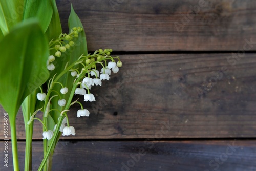 pretty bouquet of fresh lily-of-the- valley on a wooden background