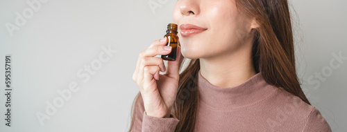 close-up view person test smelling aroma essential oil in the bottle for diffuser