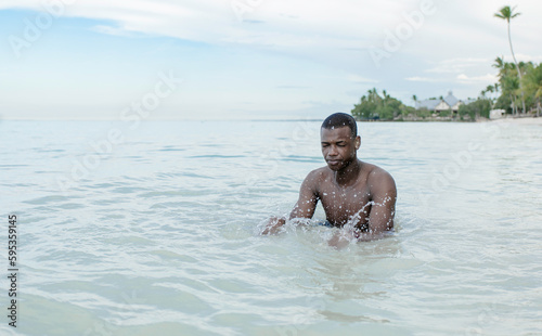 Young black man enjoying crystal clear Caribbean waters