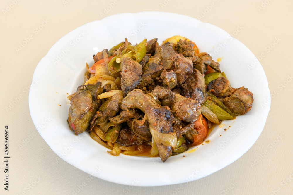 Turkish and Arabic Traditional Ramadan doner kebab with tasty tomato sauce and rice or turkish pilav in white plate on wood table background. ( Pilav ustu doner)