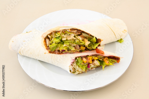 Cig kofte (raw meatball) with lettuce, tomato, pickle and lemon, hot Chee kofta. Turkish local raw food concept.Table scene of assorted take out or delivery foods. Doritoslu cig kofte durum.