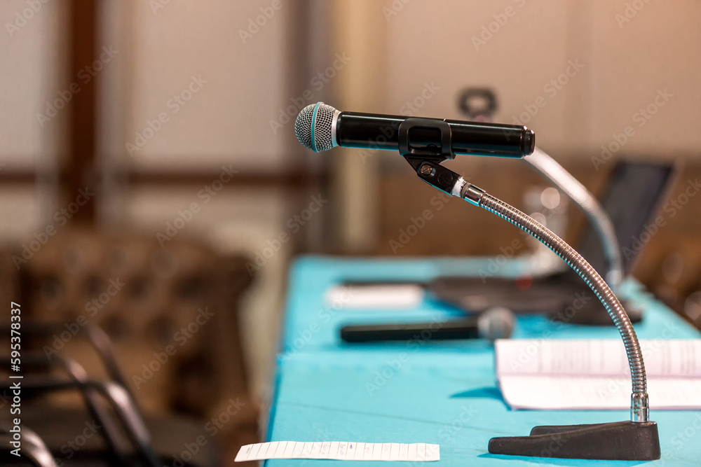 Microphone in concert hall or conference room soft and blur style for background. Microphone over the Abstract blurred photo of conference hall or seminar room background.