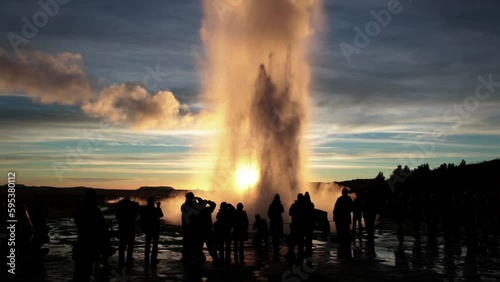 Tourist crowd silouhettes at sunset Geyser eruption, Geysir Iceland photo