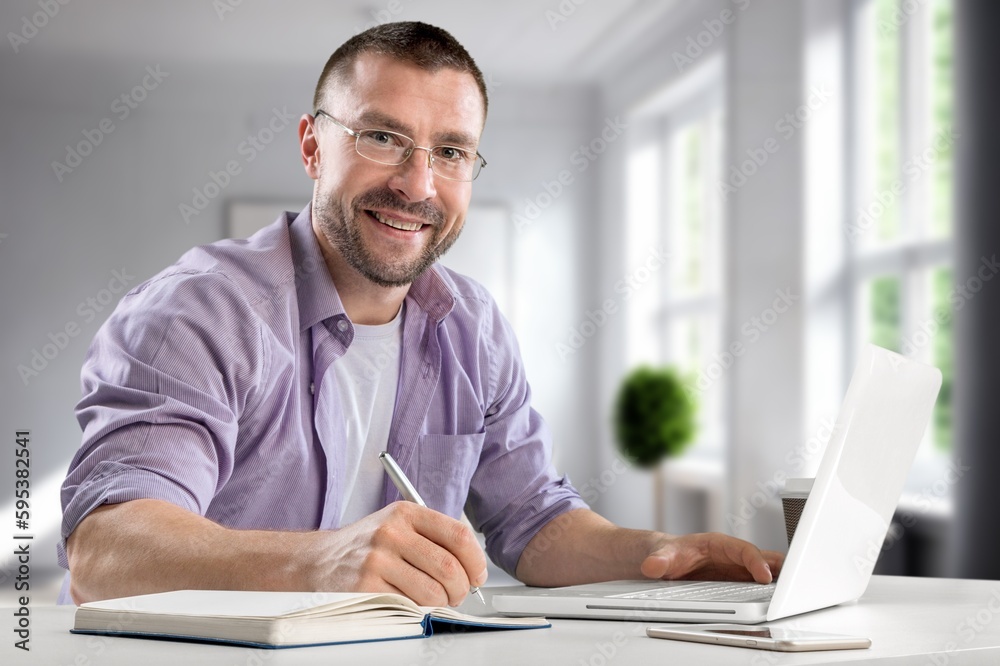 Happy young businessman working inside office Happy young businessman working inside office