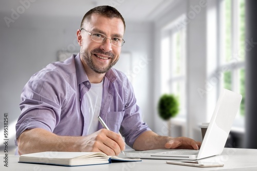 Happy young businessman working inside office