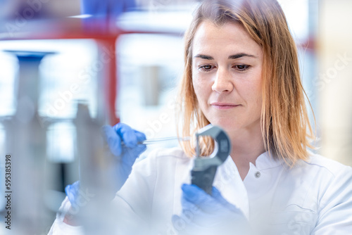 Photos measurement of material for research by a young woman in a scientific laboratory